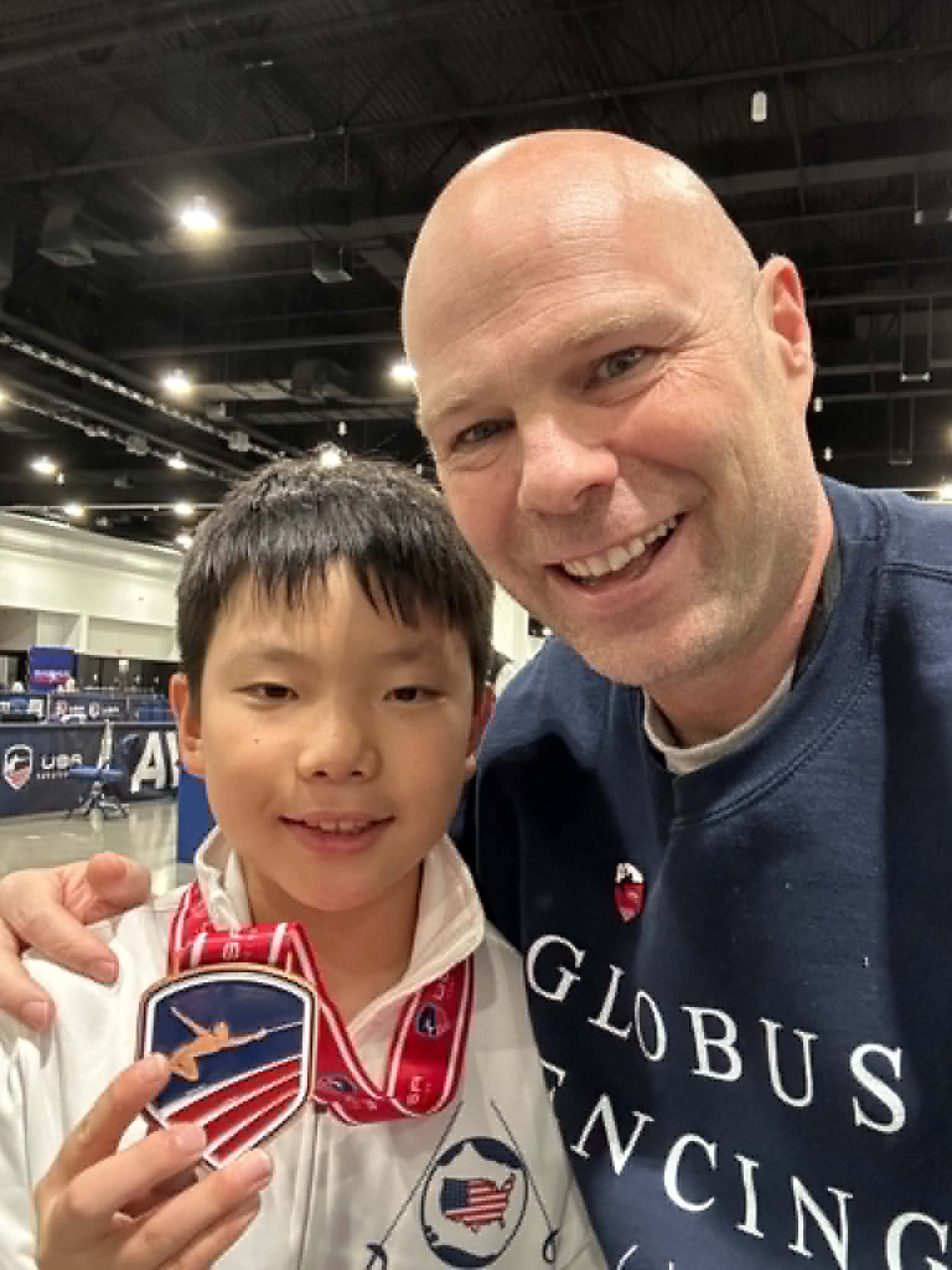 Meester Paul Corteyn met een jonge schermer en zijn medaille op een nationaal toernooi